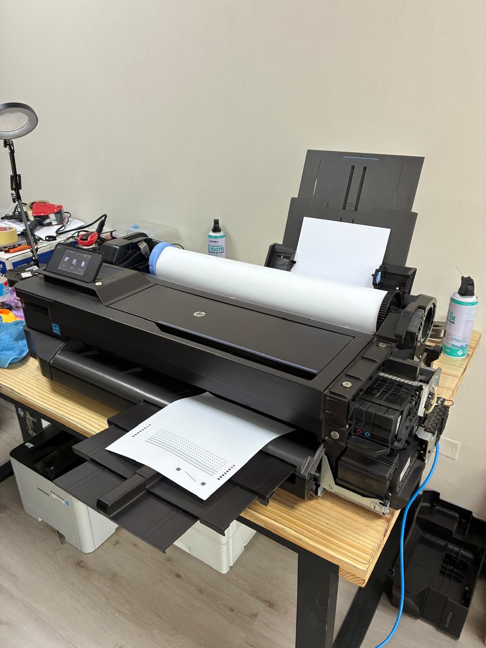 Técnico de ITServicios trabajando en la mantención de un plotter de gran formato